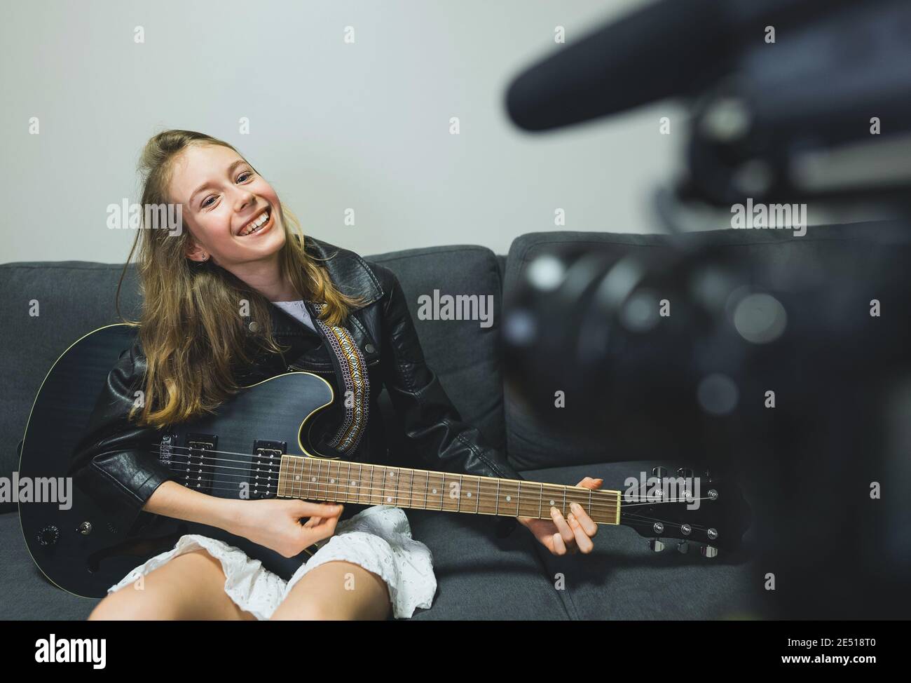 Teenage girl with semi-acoustic guitar in front of the video camera. Stock Photo