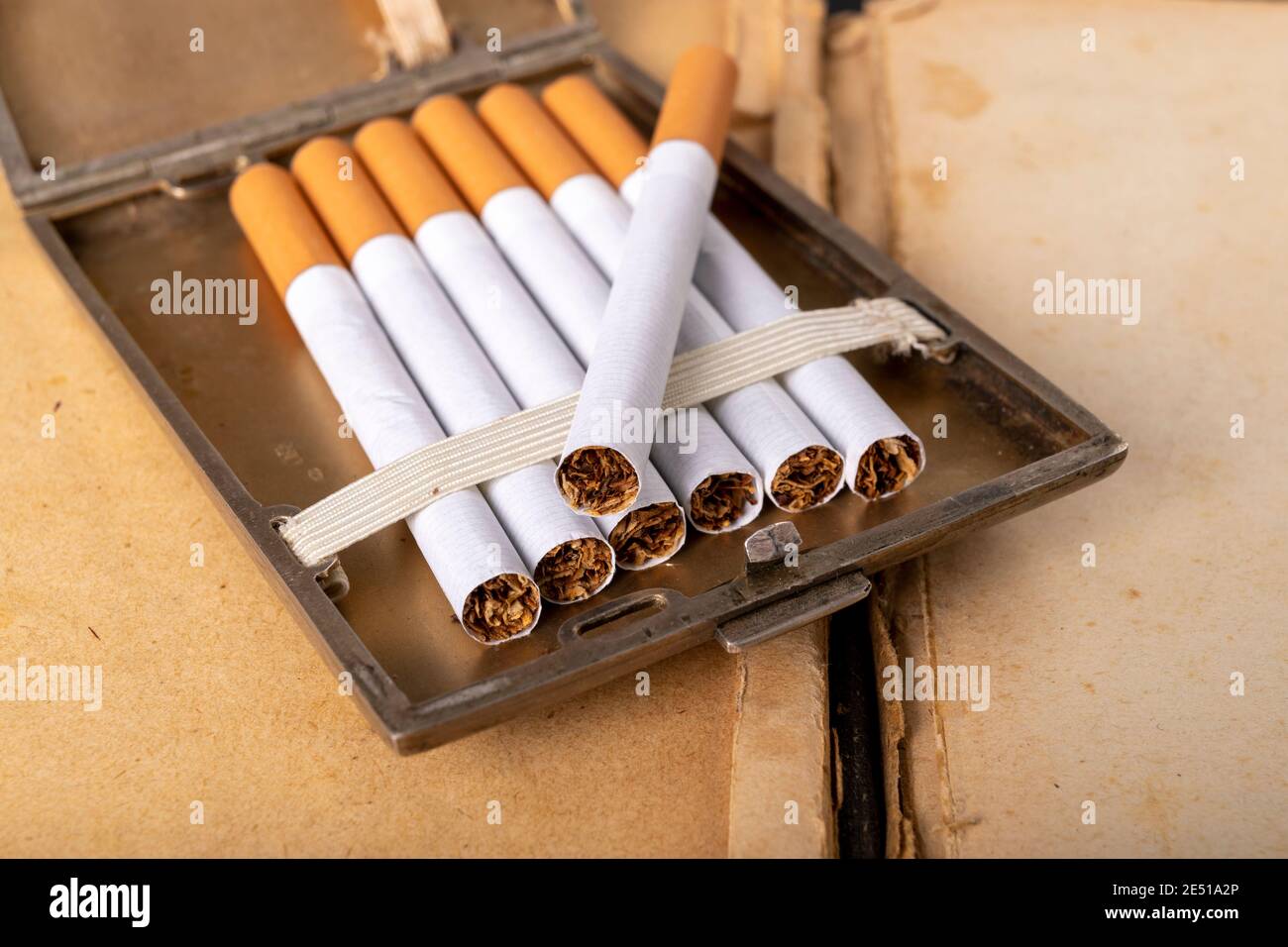are cigarettes stimulants Cigarettes in a metal cigarette case. Stimulants for adults dangerous to  health. Dark background Stock Photo