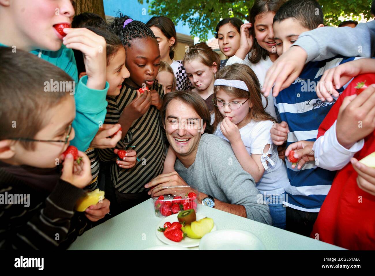 French TV chef Cyril Lignac is surrounded by school children as he helps launching the campaign 'A Fruit at the Recess' to spur on children to eat more fruits, in a school in Bordeaux, southwestern France on May 6, 2008. Photo by Patrick Bernard/ABACAPRESS.COM Stock Photo