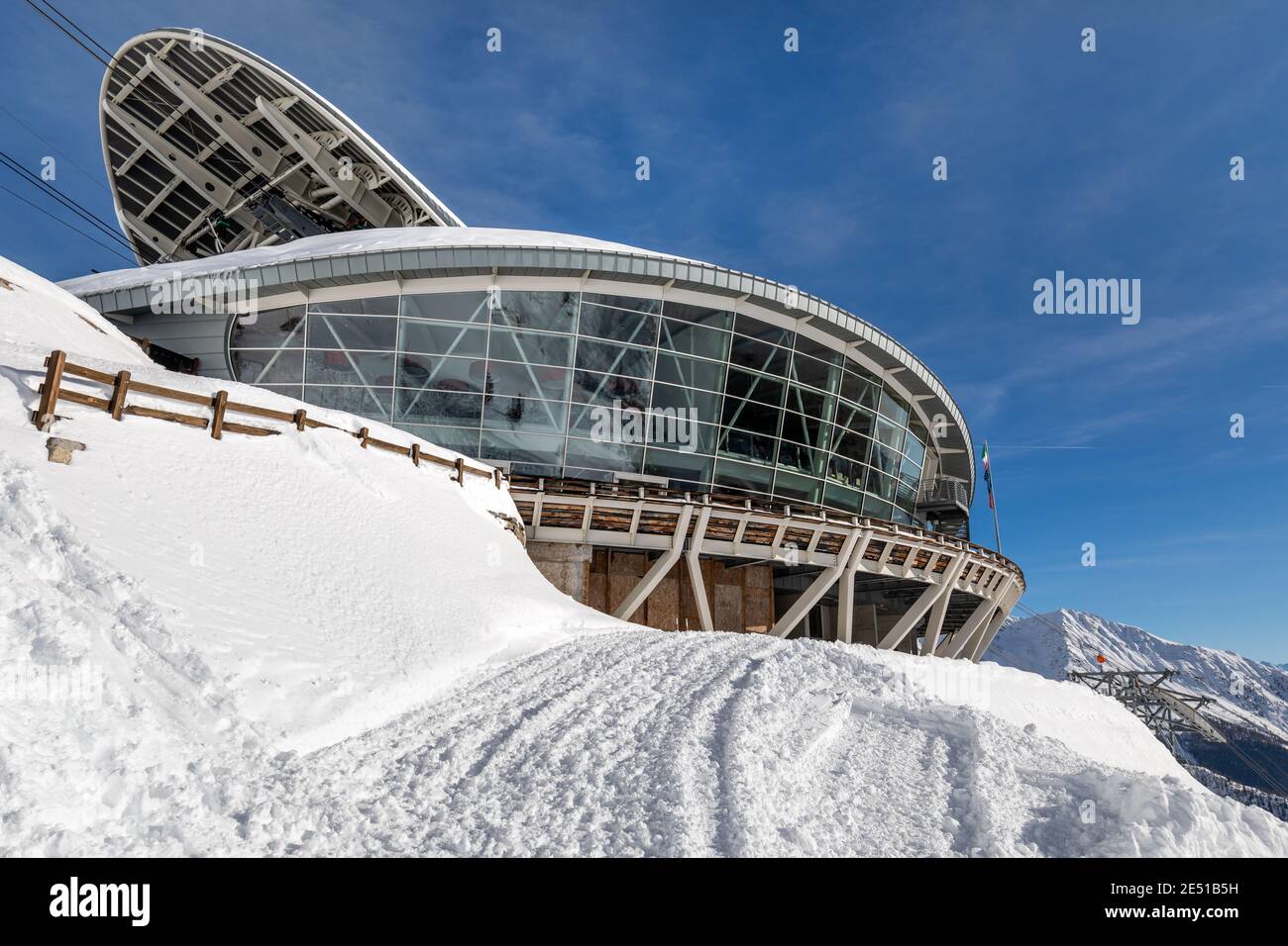 Wide angle view of the middle ropeway station on the Italian side of Mont Blanc, surrounded by snow under a blue sky with sparse clouds Stock Photo