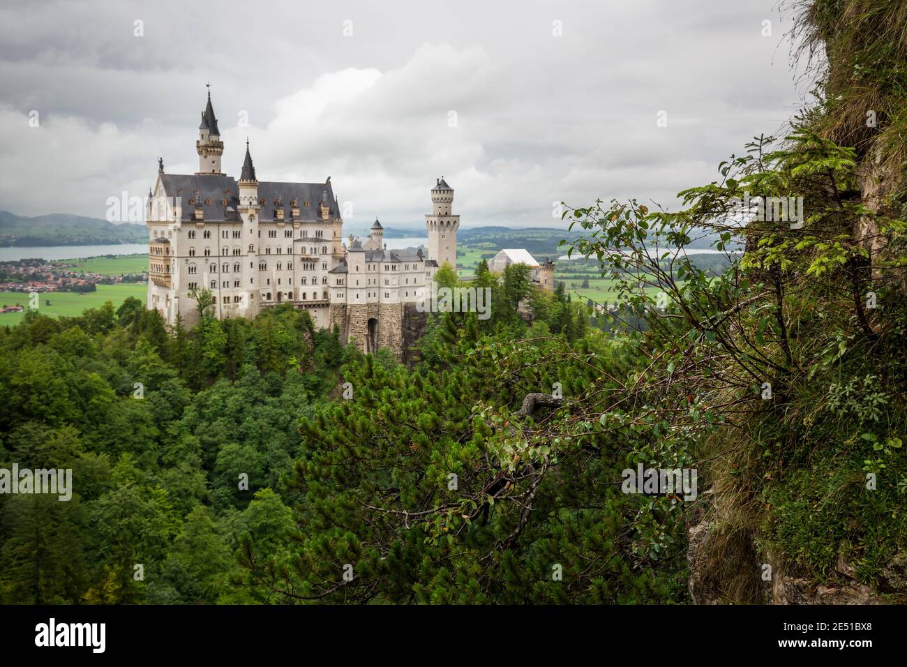 Wide angle view of a German landscape with an ancient castle in the foreground, against a dark cloudy sky Stock Photo