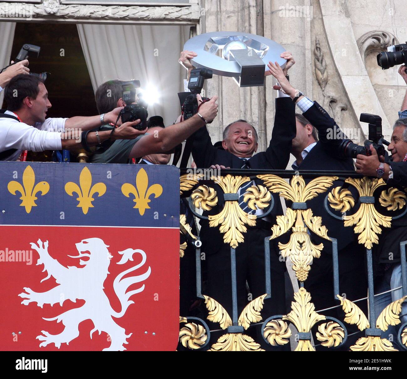 Lyon's president Jean-Michel Aulas holds the trophy on the balcony of City  Hall in front of team supporters celebrating on Terreaux Square in Lyon,  France on May 18, 2008. Lyon wrapped up