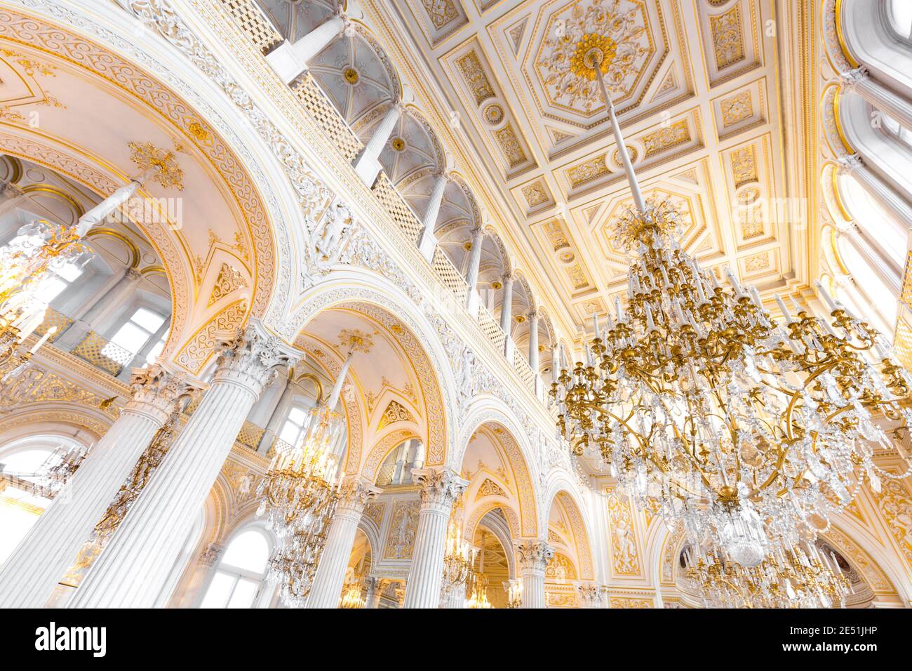 Wide angle view from below of a white and gold ball room in the Ermitage museum, lit by large chandeliers Stock Photo