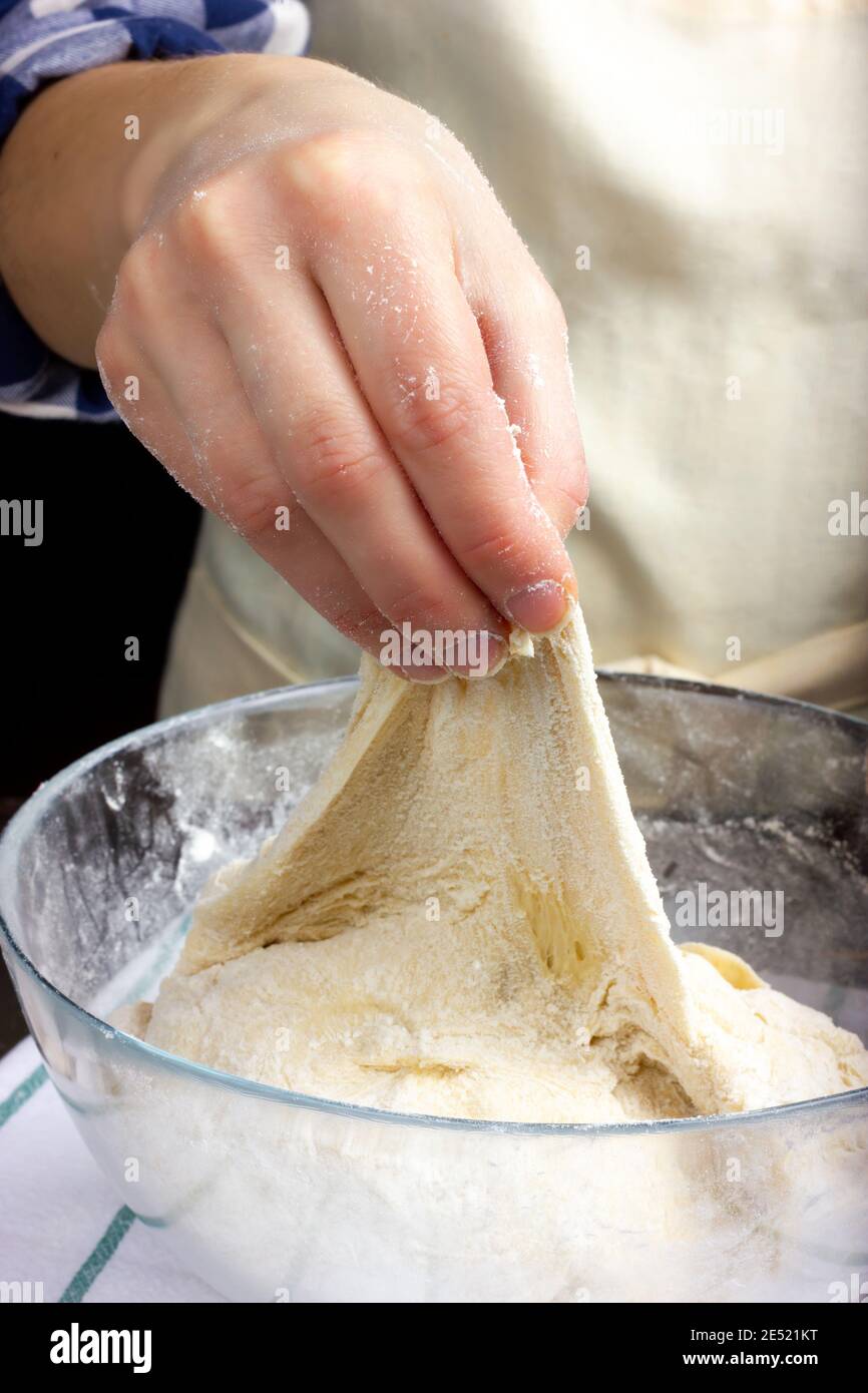 The baker kneads the bread dough. Rustic dough kneading. Stock Photo