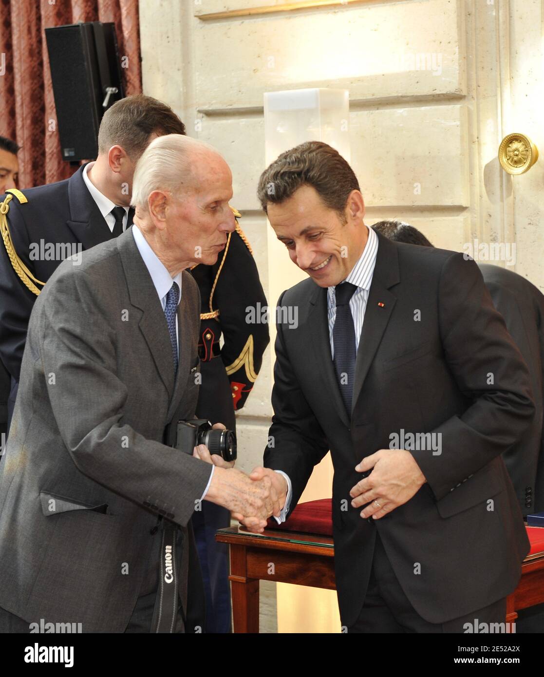 French President Nicolas Sarkozy shakes hands with Yann Arthus-Bertrand's father during a ceremony to award renowned French photographer and environmentalist Yann Arthus-Bertrand with the medal of Officier de l'Ordre National du Merite, at the Elysee Palace in Paris, France on June 17, 2008. Photo by Mousse/ABACAPRESS.COM Stock Photo