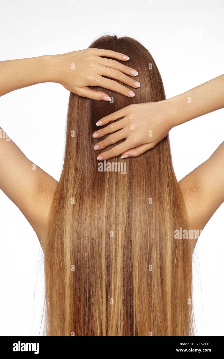 Beautiful yong Woman with Long Straight dark Blond Hair. Fashion Model with Smooth Gloss Hairstyle on White Background. Keratine Treatment Stock Photo
