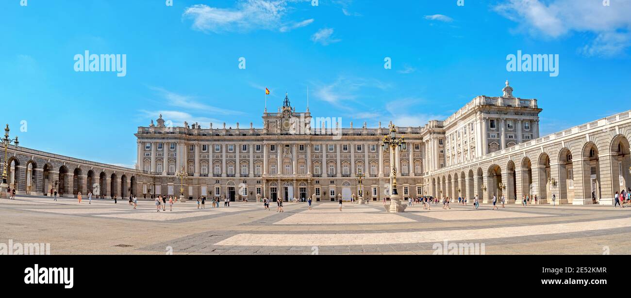 Panoramic view of Palacio Real or Royal Palace across Plaza de la Armeria square with tourists in downtown. Madrid, Spain Stock Photo