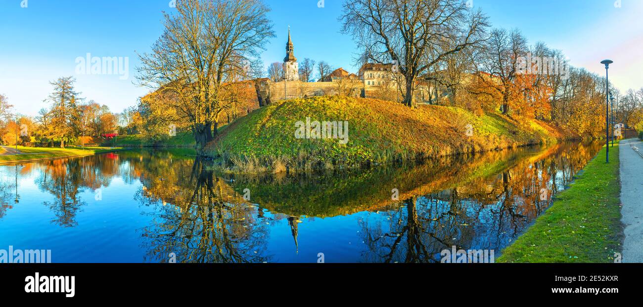 Panoramic landscape with park and pond along medieval city walls of Old Town at autumn time. Tallinn, Estonia Stock Photo