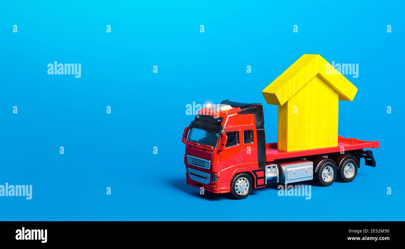 Red freight truck carrier with a yellow house figure. Home moving company. Transportation service and delivery of complex and oversized cargo. Cargo i Stock Photo