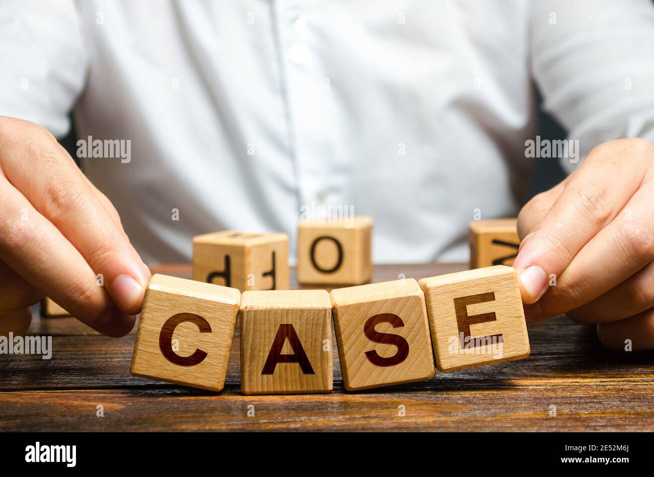 Man raises falling apart blocks with word Case. Concept of collapse of a trial, insufficient evidence, innocence. Closing court case. Defense lawyer a Stock Photo