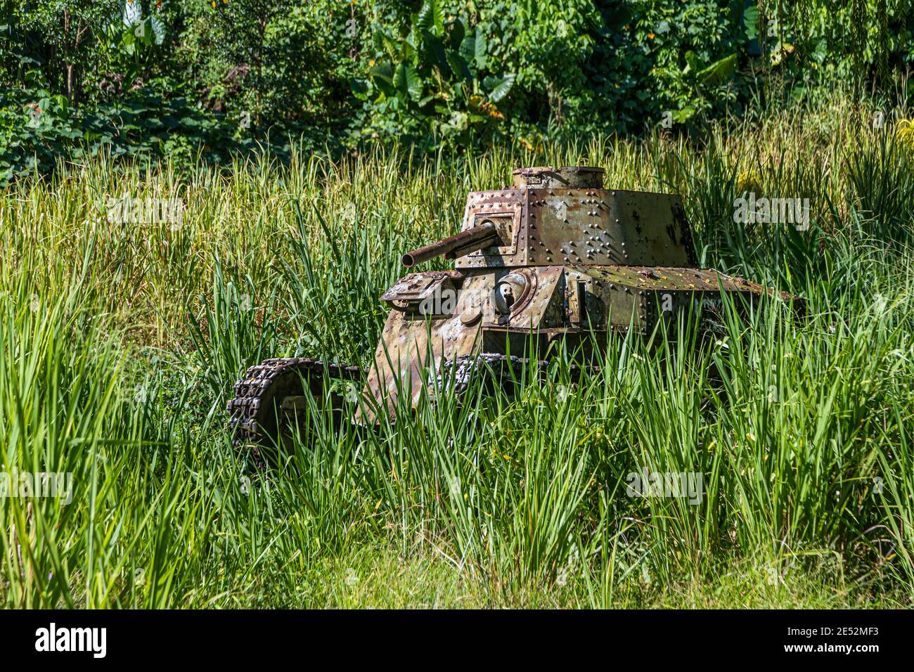 Abandoned tank in the jungle of Bougainville, Kieta, Papua New Guinea. In the last 20 years in the city of Kieta grass has not yet grown everywhere over the traces of the civil war Stock Photo