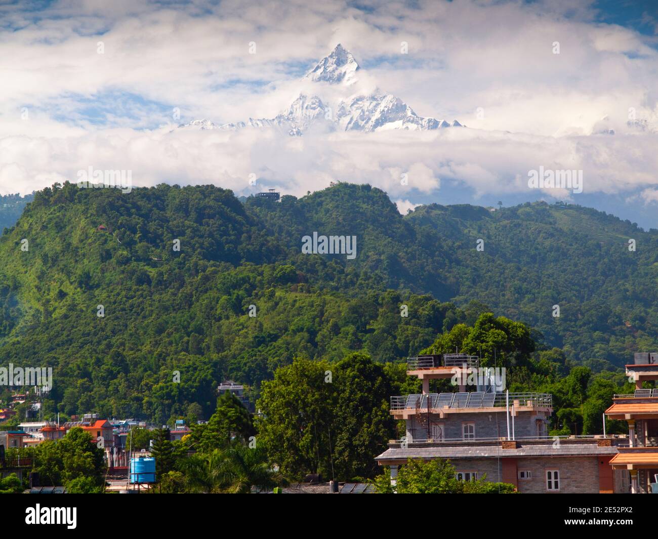 The near-perfect pyramid of Machhapuchhre (6993m) 'fishtail mountain' surrounded by monsoon clouds, Pokhara, Nepal Stock Photo