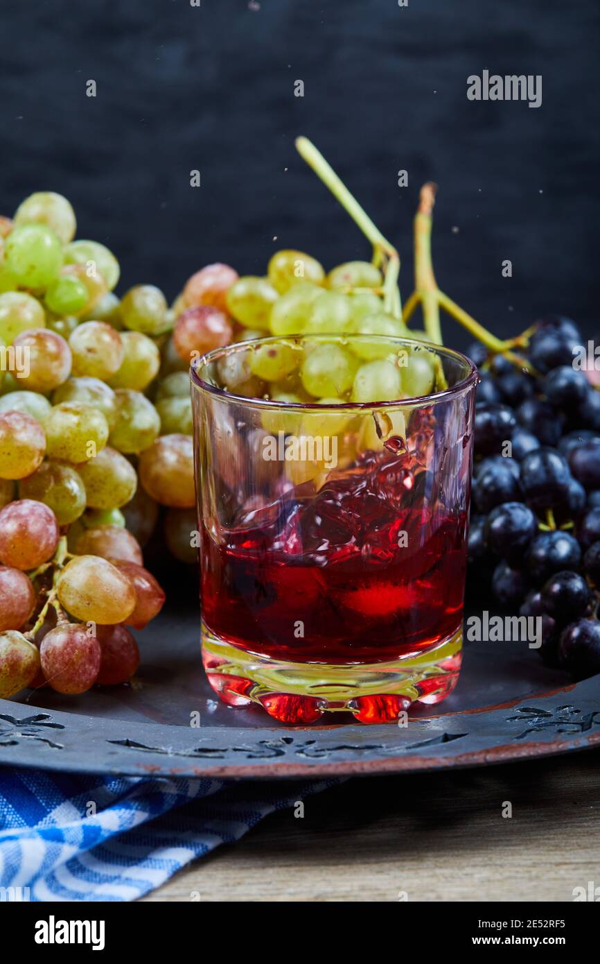 Bunch of grapes and a glass of juice on ceramic plate, close up Stock ...