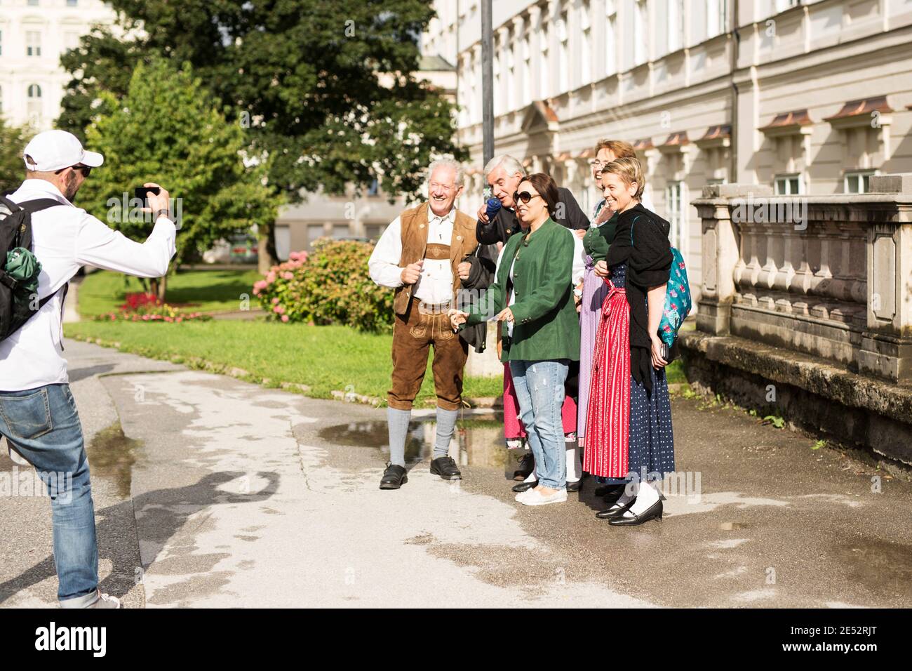 Tourists take photos with Austrians in traditional dress outside the Mirabell Palace (Schloss) in Salzburg, Austria. Stock Photo