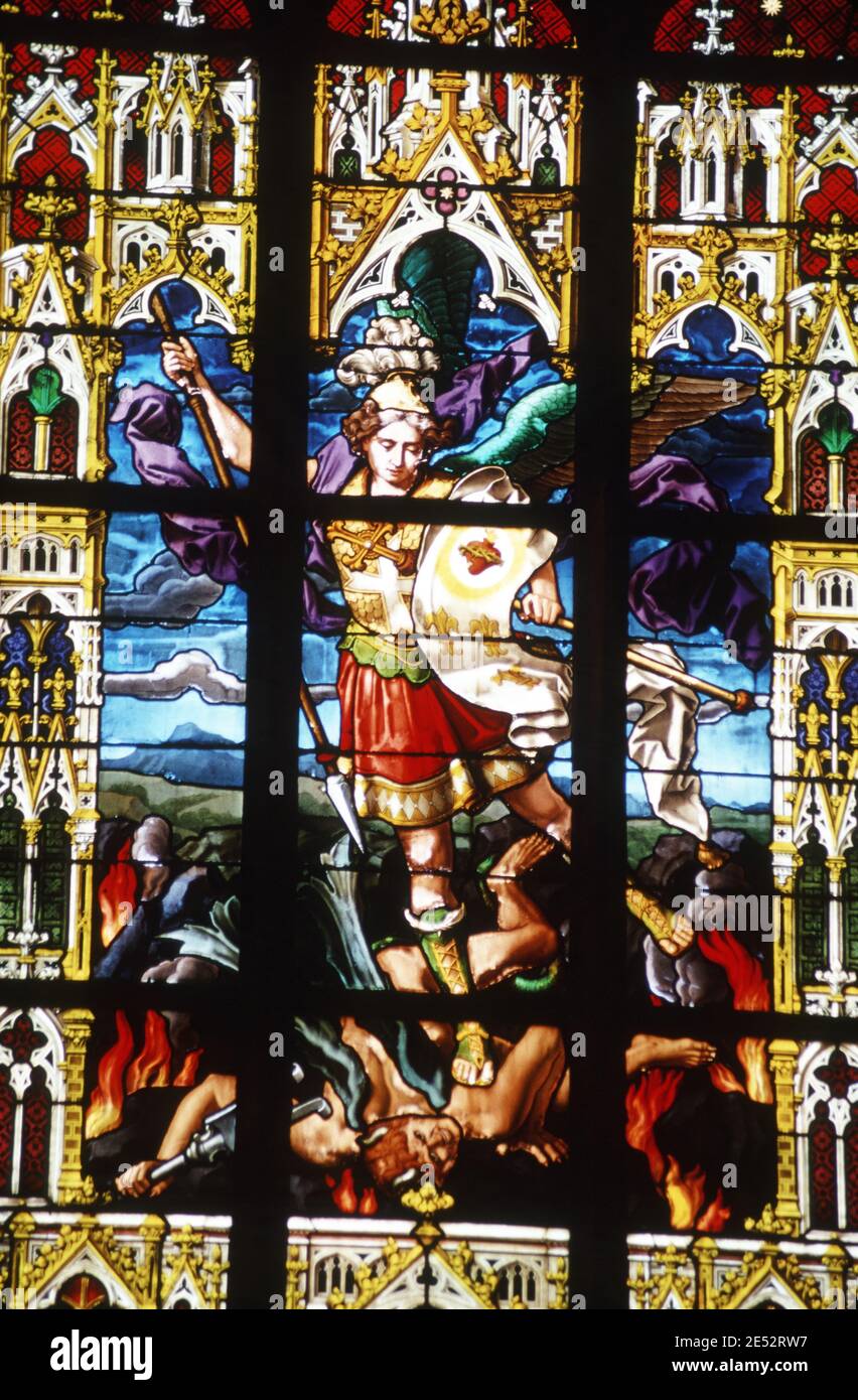 Stained Glass WIndows Inside Basilique Notre Dame du Roncier in Josselin depicting St. Michael Vanquishing Satan Stock Photo