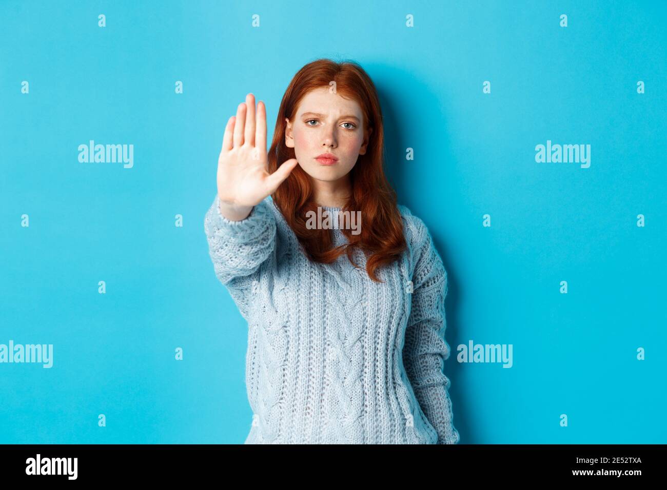 Serious and confident redhead girl telling to stop, saying no, showing ...
