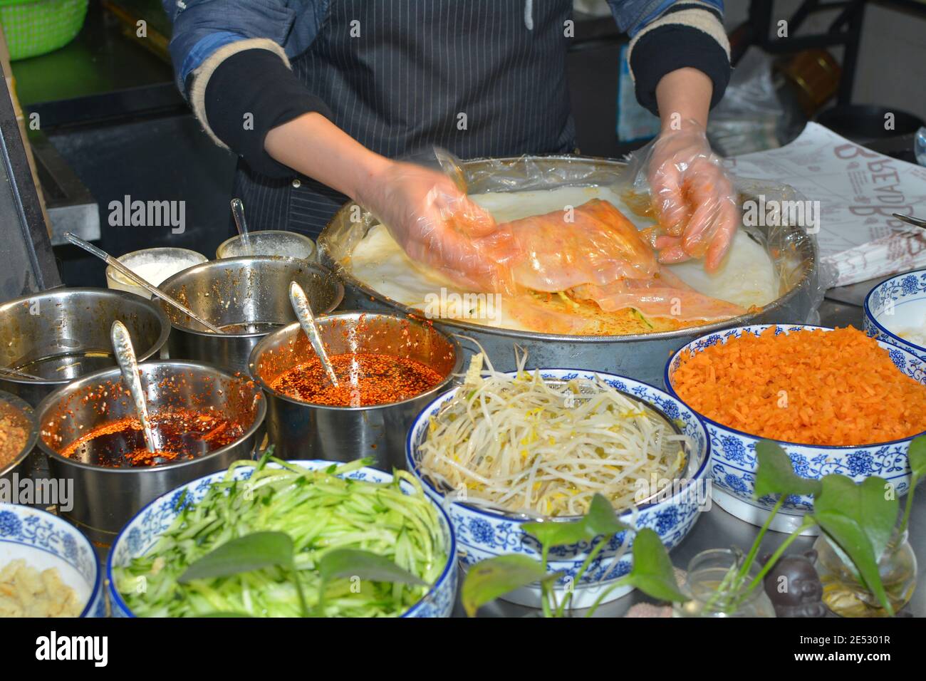 Street food market in Jiaxing, Zhejiang, China. Pancake or spring rolls with vegetables. Jan 2020 Stock Photo