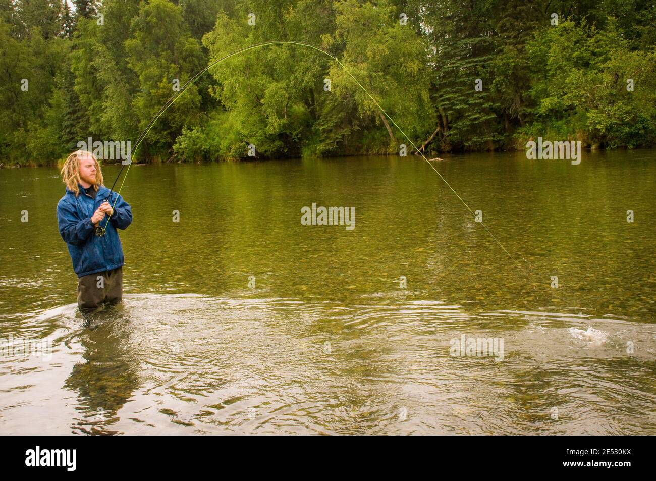 This young man is enjoying a quiet afternoon of Fly Fishing on the Kijik River in Southwest Alaska. Stock Photo