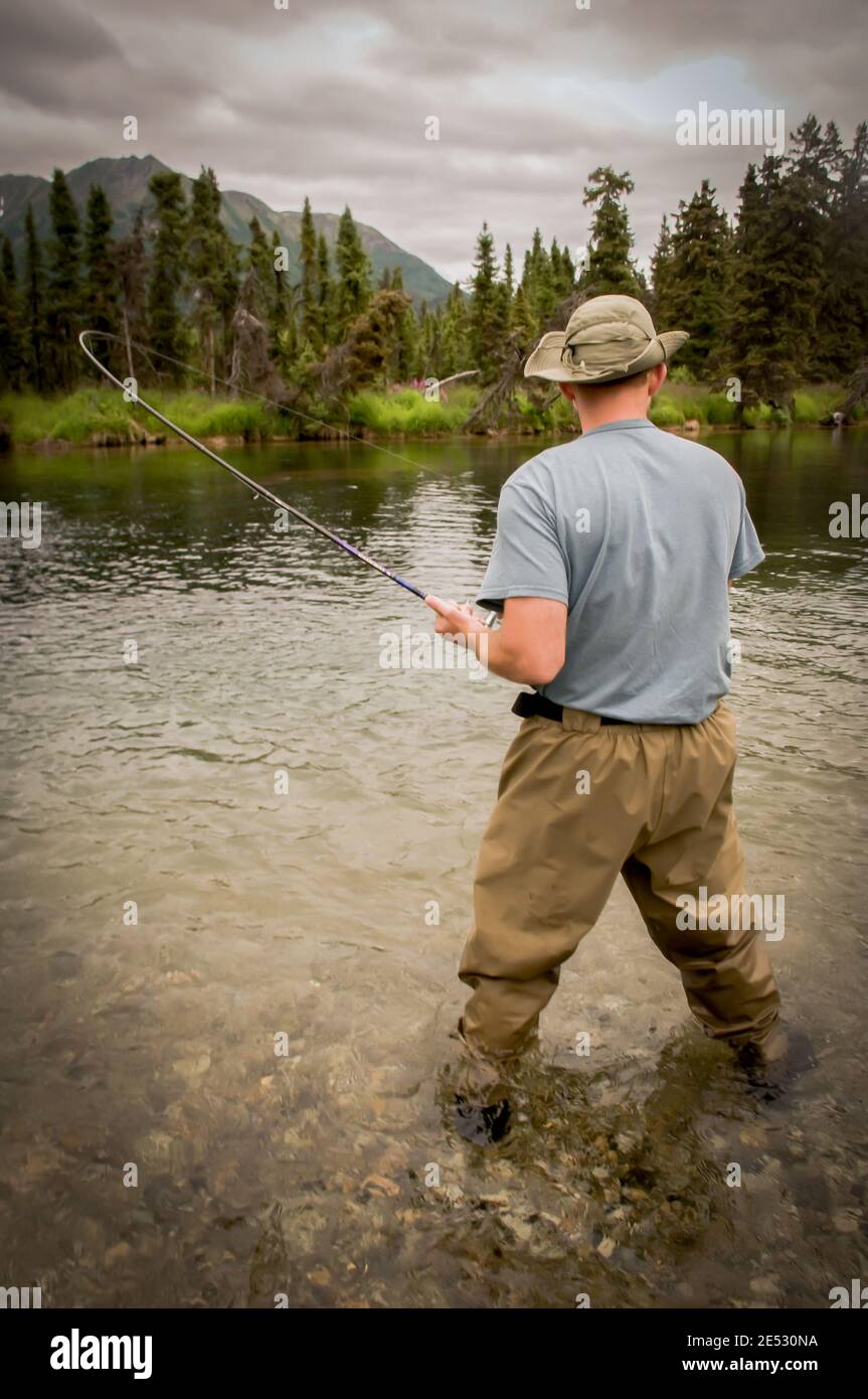 Reeling in a Salmon catch on Lake Kijik near Lake Clark National Park Alaska. Stock Photo