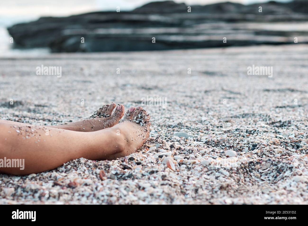 Woman lying with shell on beach hi-res stock photography and images - Alamy