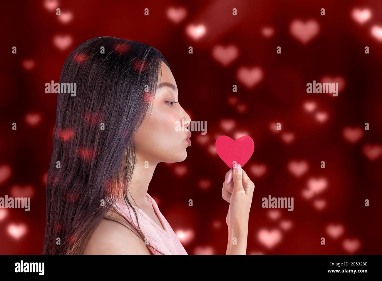 Asian woman holding the red heart with a colored background. Valentines ...