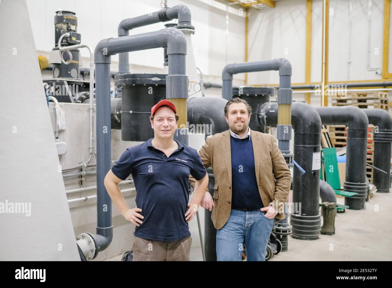 20 January 2021, Lower Saxony, Gronau (Leine): Tarek Hermes (l), Managing Director, and Ludwig von Brockhausen, Sales Manager of Shrimp Farm New Seas, stand in the shrimp farm. Shrimps are becoming increasingly popular, and not just in upscale cuisine. Several German companies are breeding crustaceans that are actually found in tropical waters. Most recently, Neue Meere has launched in Gronau, Lower Saxony - the start-up wants to market its delicacies via a farm shop and the Internet. Photo: Ole Spata/dpa Stock Photo