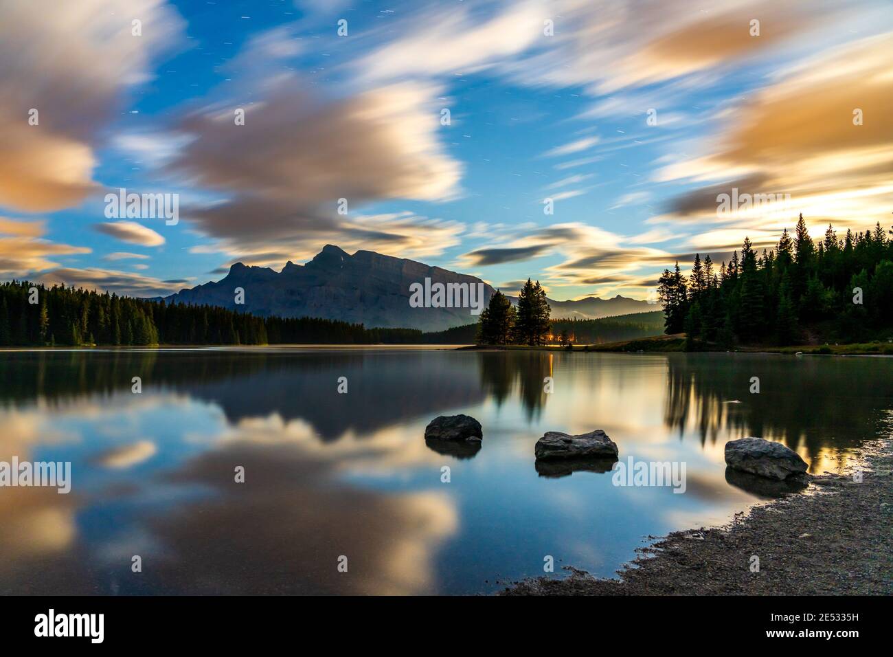 Two Jack Lake at daybreak, starry sky and colorful clouds reflected on the water surface. Beautiful landscape in Banff National Park, Canadian Rockies Stock Photo