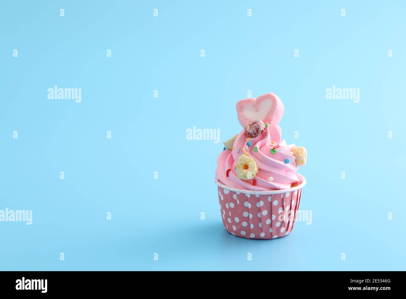 pink cupcake isolated in blue background Stock Photo - Alamy