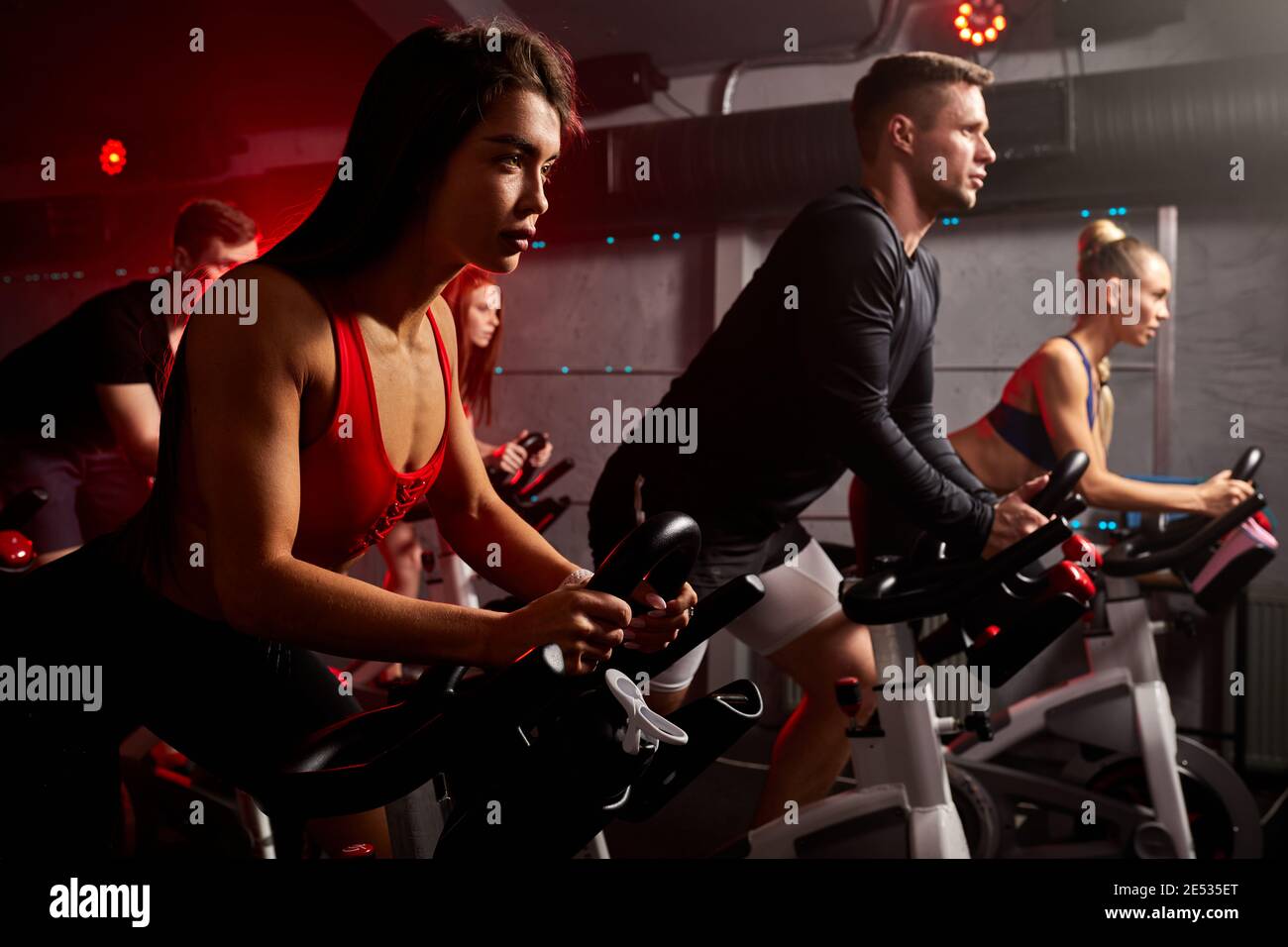 men and women biking in gym, exercising legs doing cardio workout cycling  bikes, spinning in health club, wearing tracksuit sportive outfit Stock  Photo - Alamy