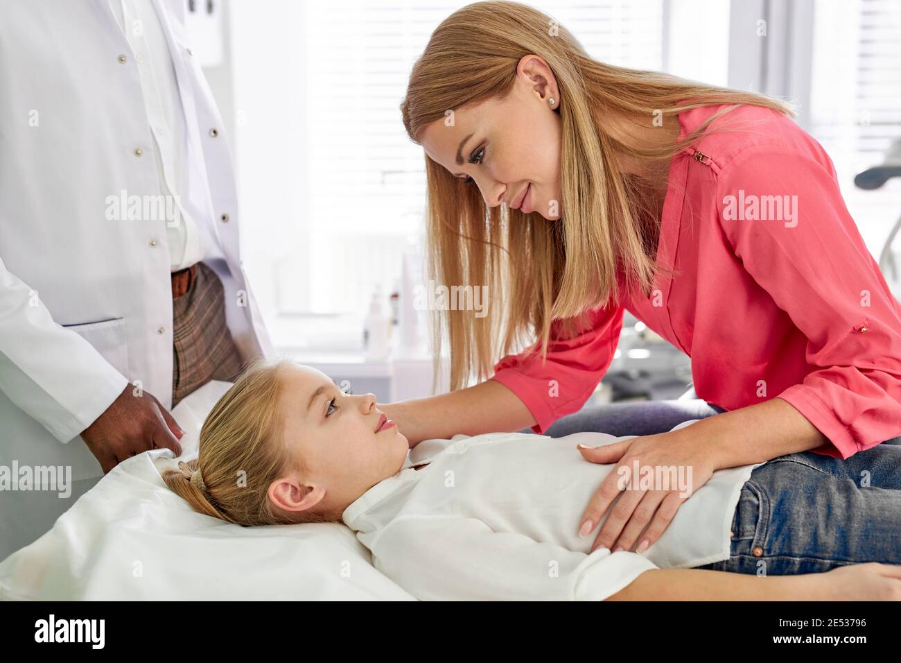 mother supporting child girl suffering from disease, cute parent have talk with her daughter lying on bed. in hospital Stock Photo