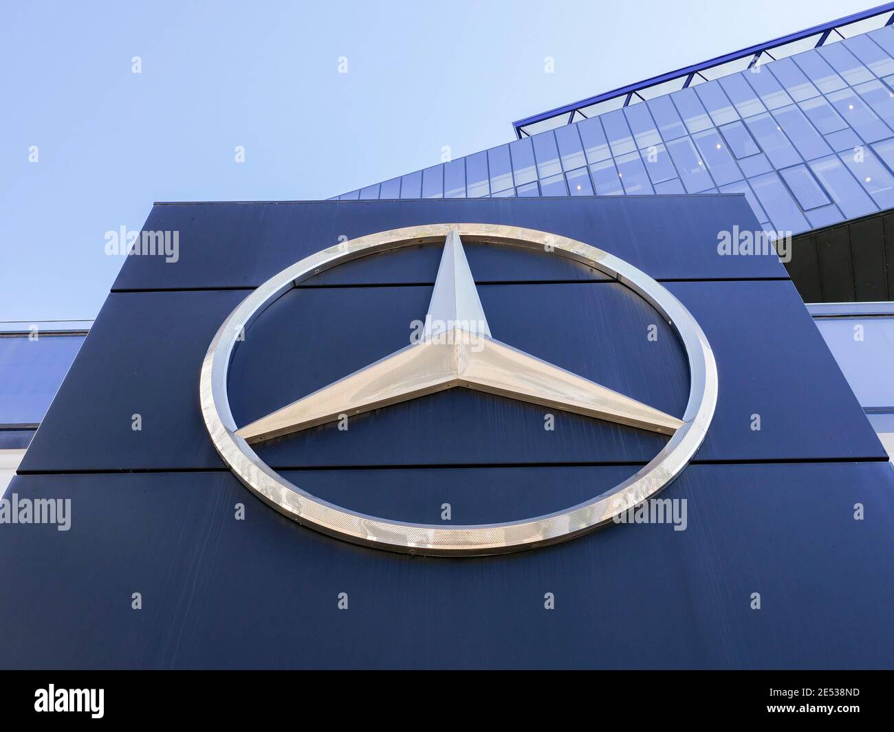 Mercedes Benz sign on a local dealership building windows. Stock Photo