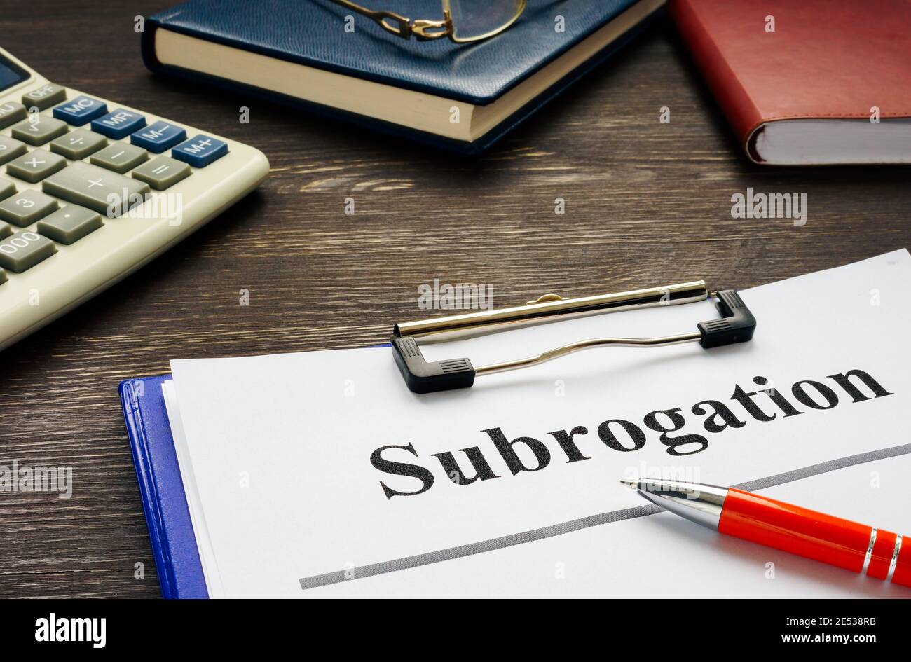 Documents about Subrogation with notepad and glasses. Stock Photo