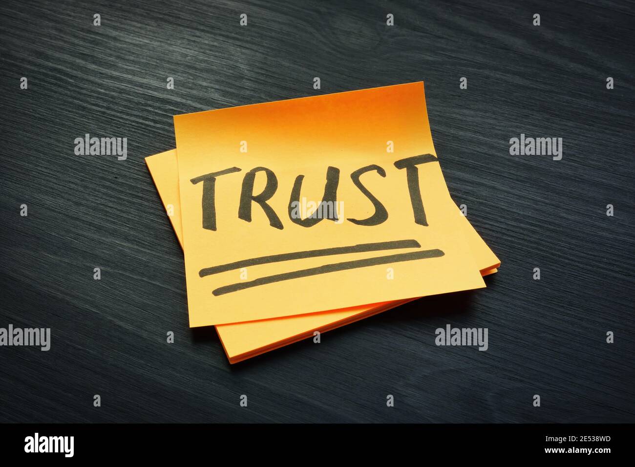 Trust concept. Piece of papers on the dark wooden desk. Stock Photo