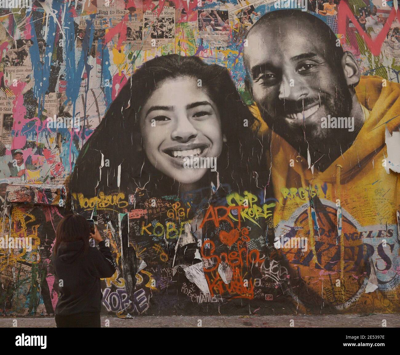 Los Angeles, United States. 26th Jan, 2021. A visitor from Atlanta records a mural honoring Kobe Bryant and his daughter Gianna Bryant on Monday, January 25, 2021 in Los Angeles. One day ahead of the anniversary of the Calabasas helicopter crash that killed the Laker legend, his 13-year-old daughter and seven others, Sen. Dianne Feinstein (D-CA) and Rep. Brad Sherman (D-CA) announced a bill Tuesday that would require Terrain Avoidance Warning Systems on all helicopters carrying six or more passengers. Photo by Jim Ruymen/UPI. Credit: UPI/Alamy Live News Stock Photo
