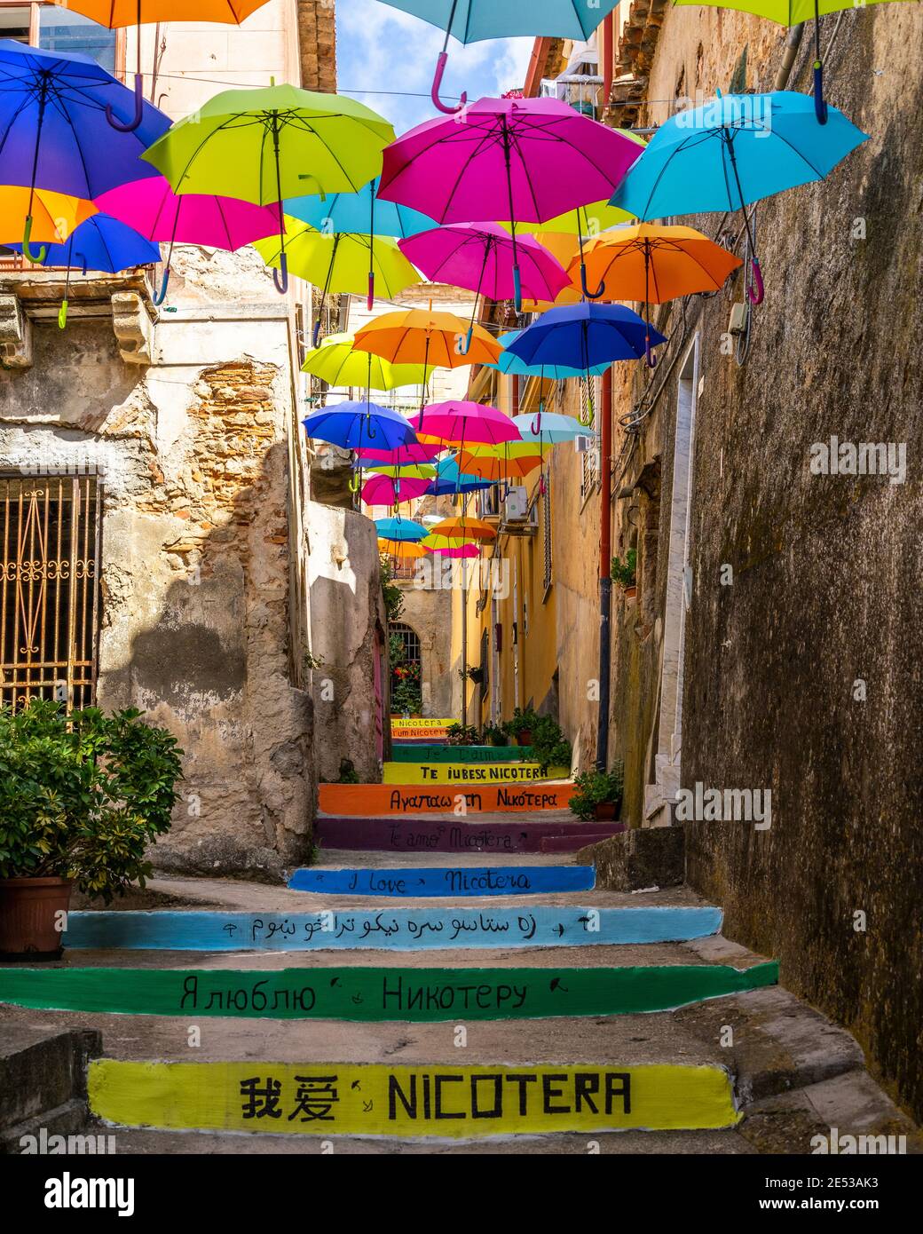 Typical narrow street with colorful floating umbrellas in Nicotera, Calabria, Italy Stock Photo