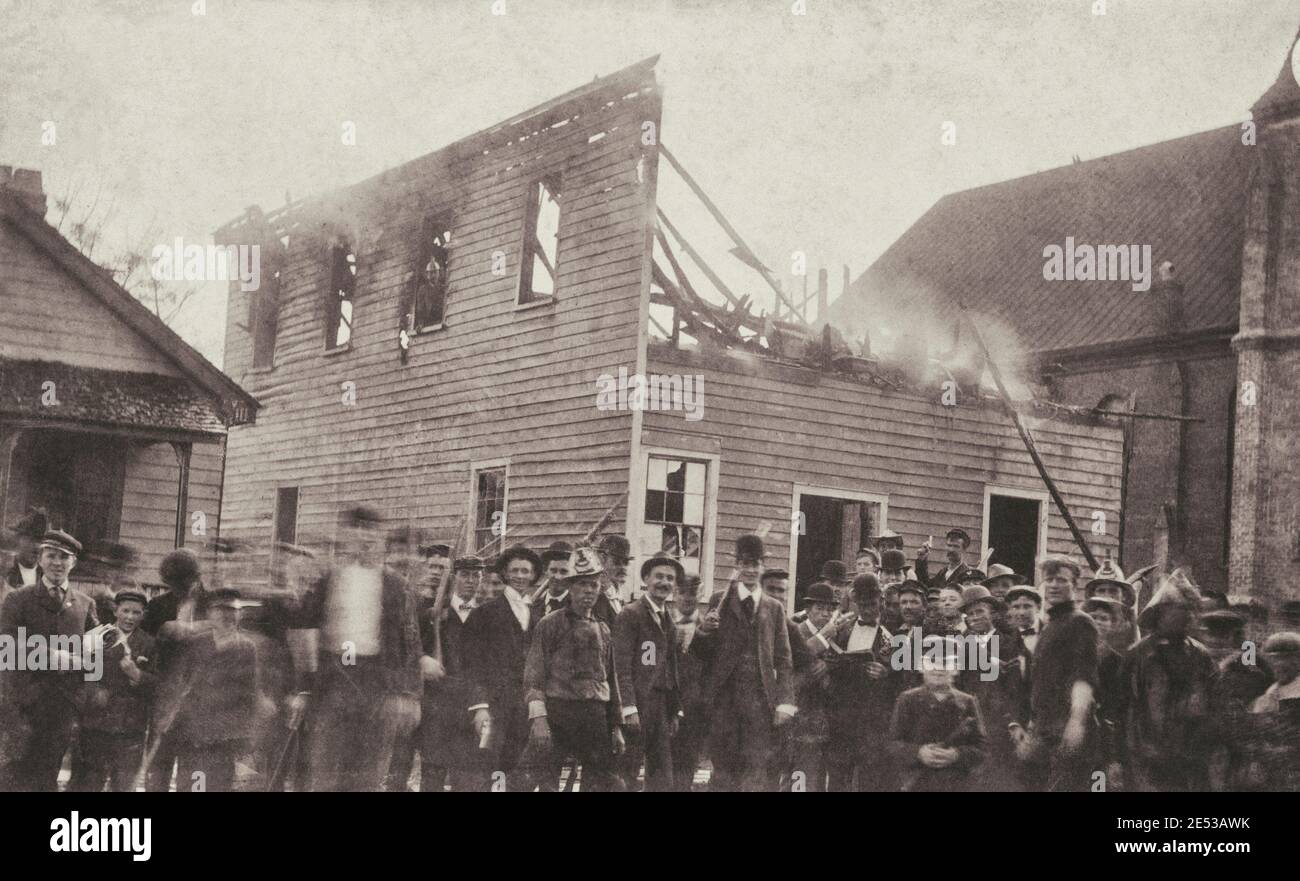 Mob posing by the ruins of The Daily Record. Wilmington, North Calolina. USA. 1898 The Wilmington insurrection of 1898, also known as the Wilmington m Stock Photo