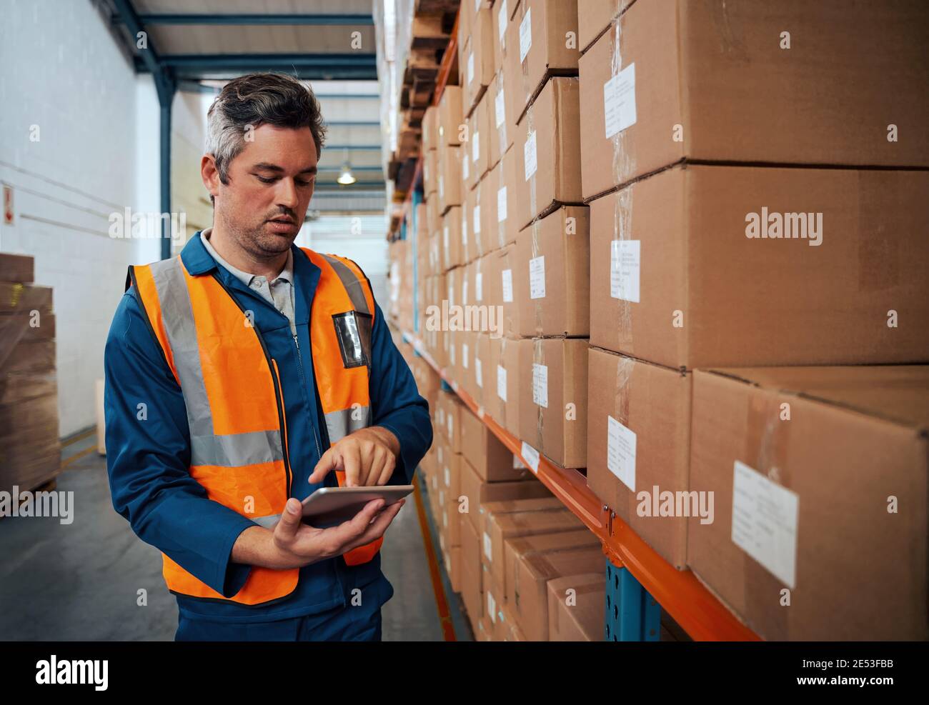 Factory technician working using digital tablet at factory warehouse Stock Photo