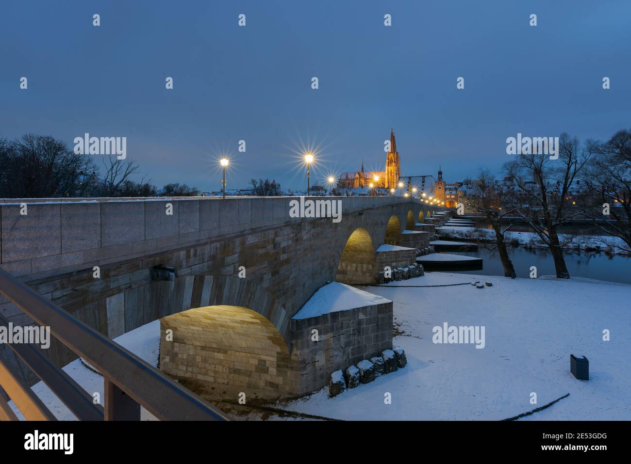 Cathedral, stone bridge and old town of Regensburg on the danube river in winter with fresh snow Stock Photo