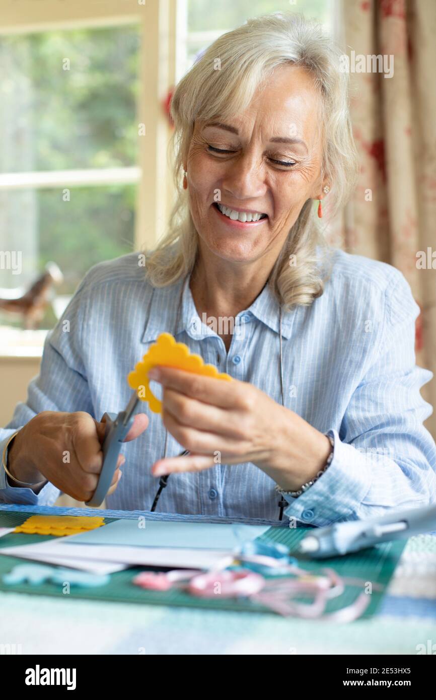 Senior Woman Doing Craft Scrapbooking Or Making Greetings Card  At Home Stock Photo