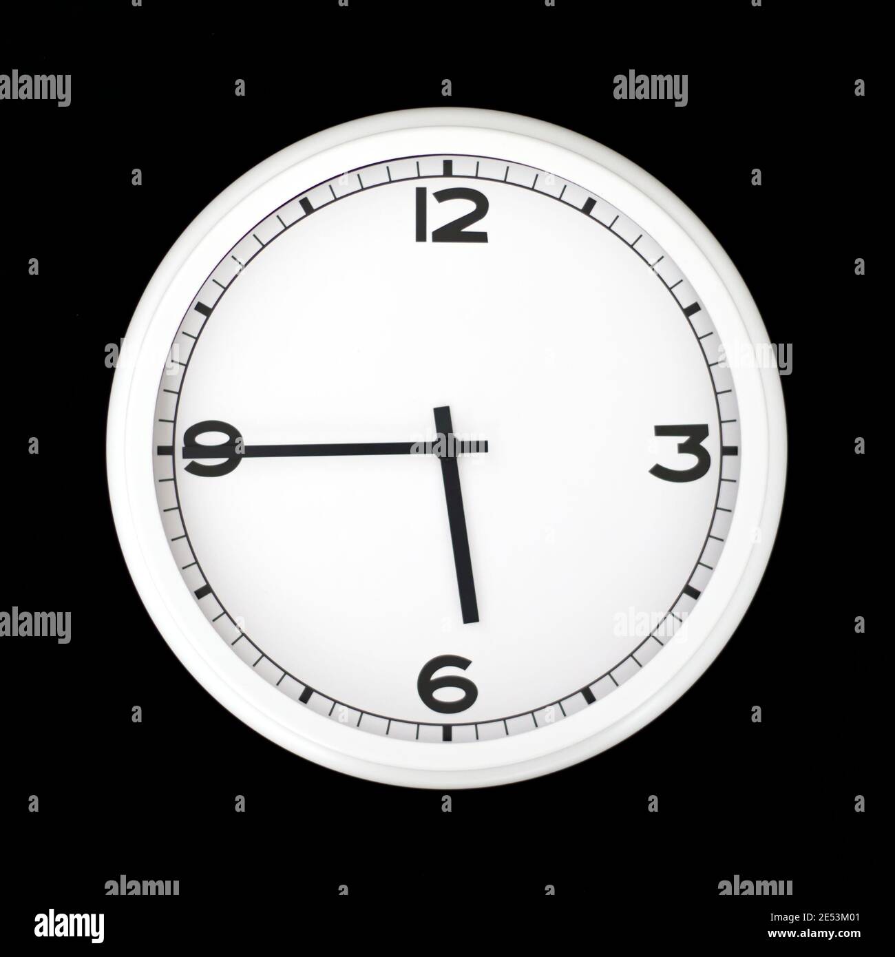 White round analog wall clock isolated on black background, its quarter to six Stock Photo Alamy