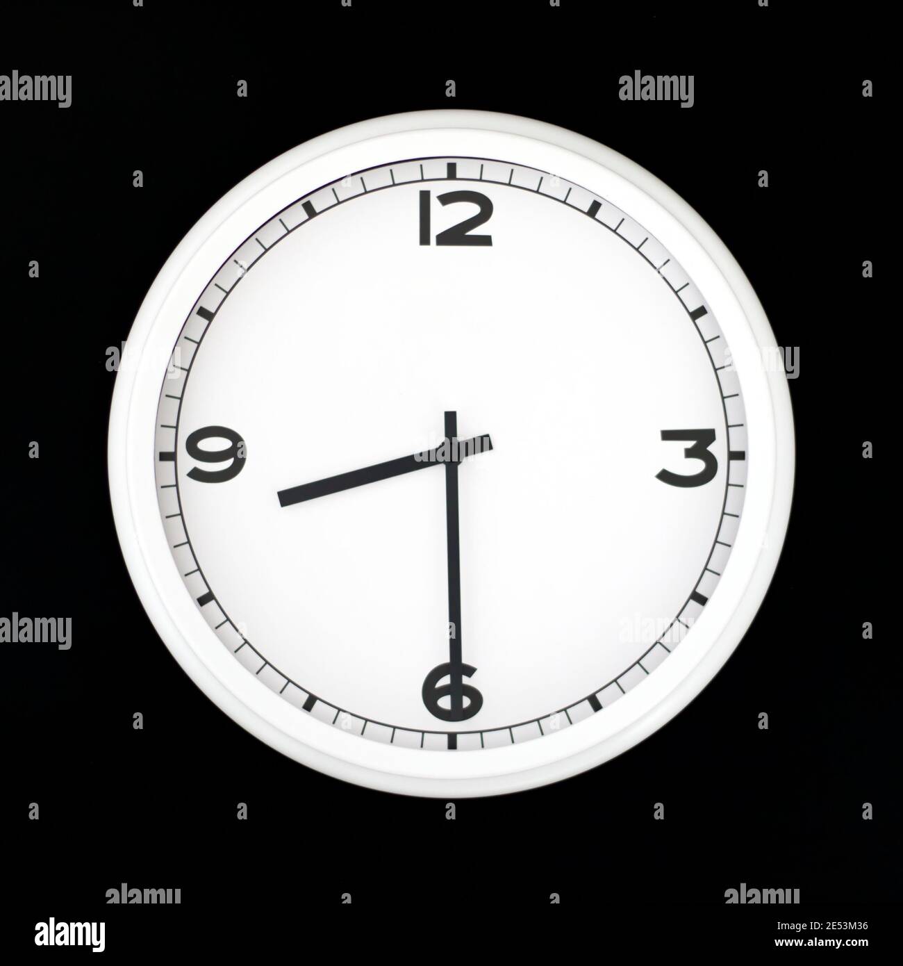 White round analog wall clock isolated on black background, its half past eight Stock Photo Alamy