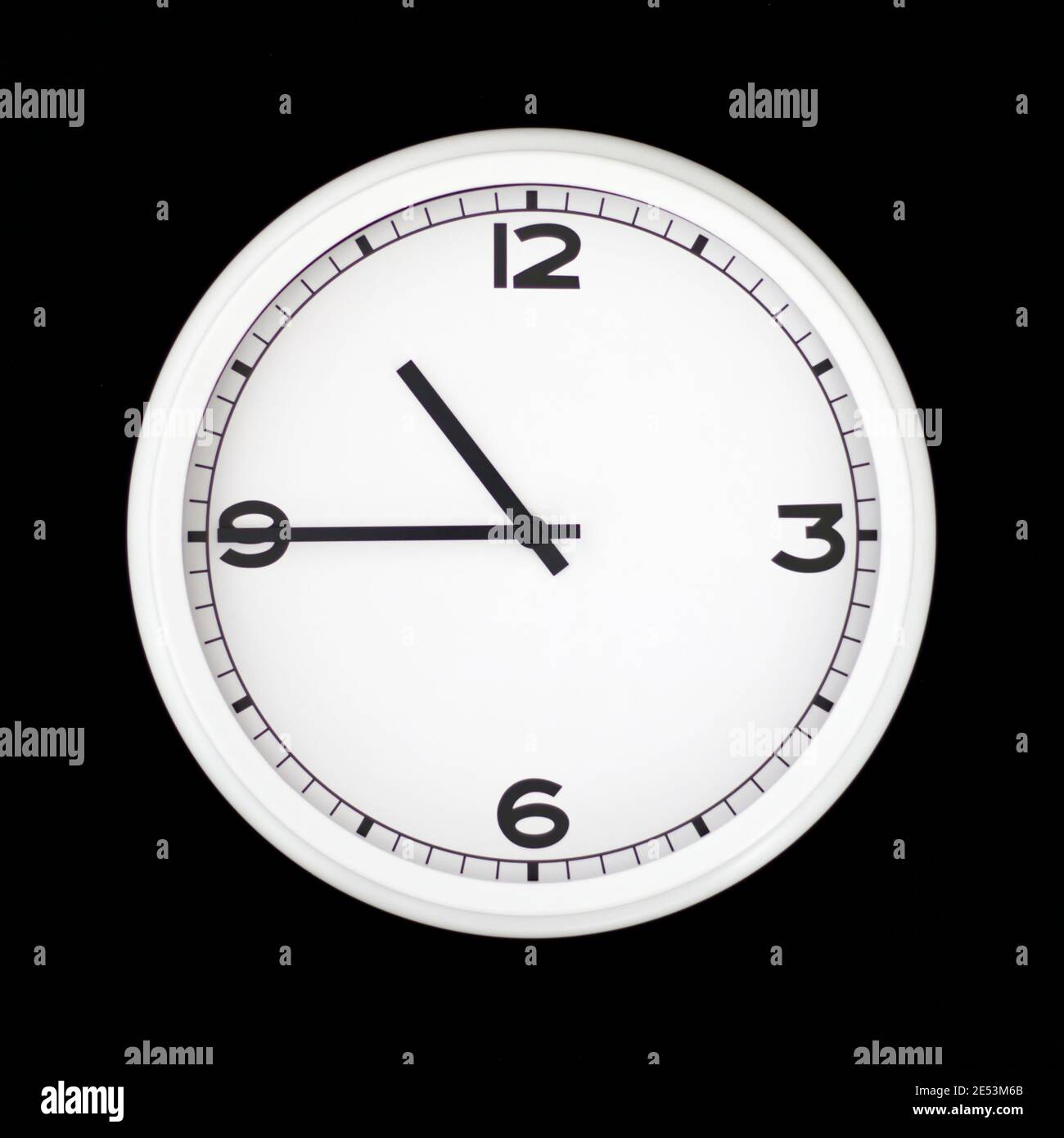White round analog wall clock isolated on black background, its quarter