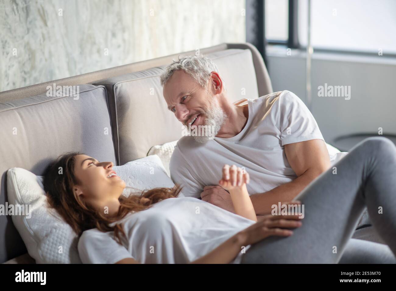 Man and woman lying on bed communicating Stock Photo