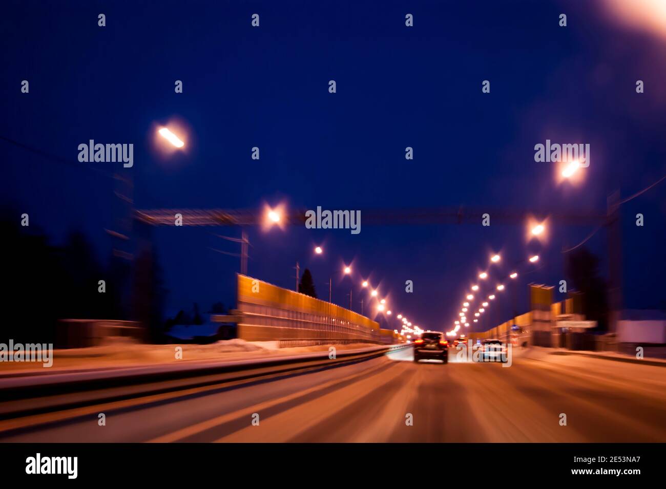 Night highway in winter. Light headlights in the dark, the movement of cars from the viewer Stock Photo