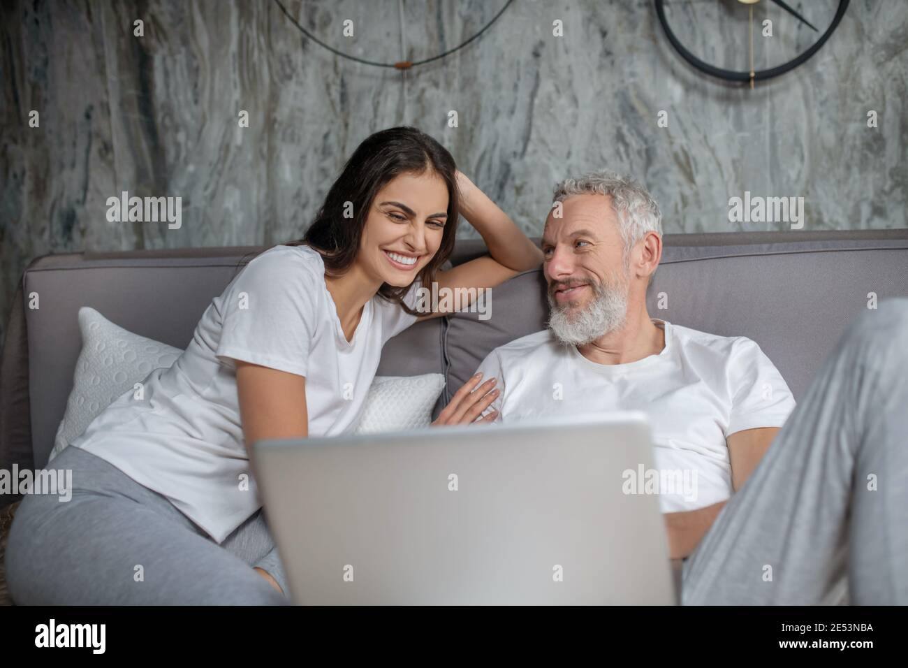 Cheerful sociable husband and wife at computer Stock Photo