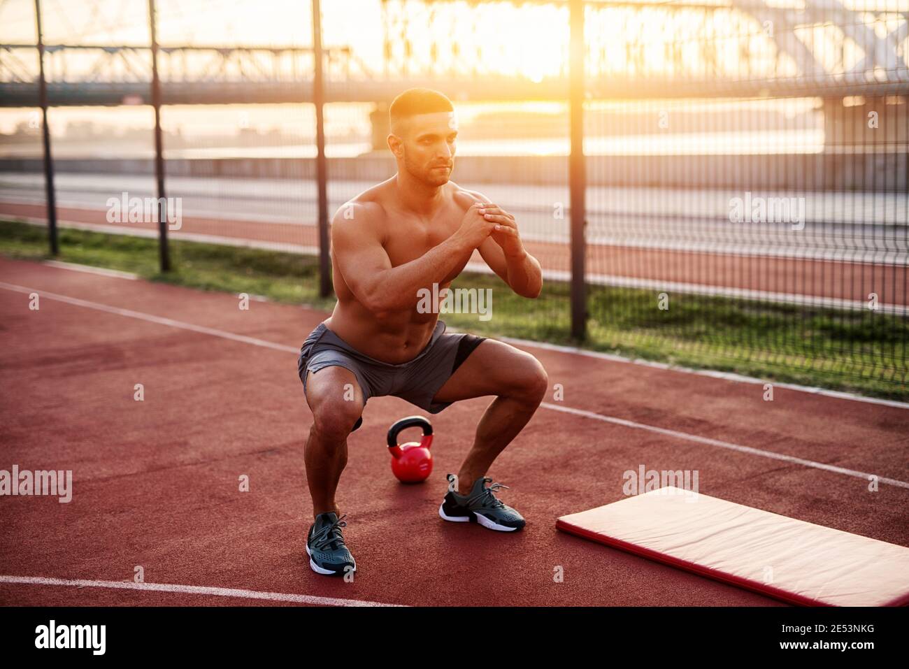 Fitness training outdoors. Handsome man working exercises in early ...
