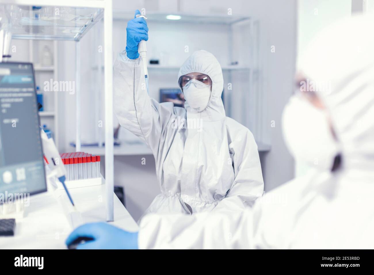 Working with micropipette using protection suit as safety precaution ...