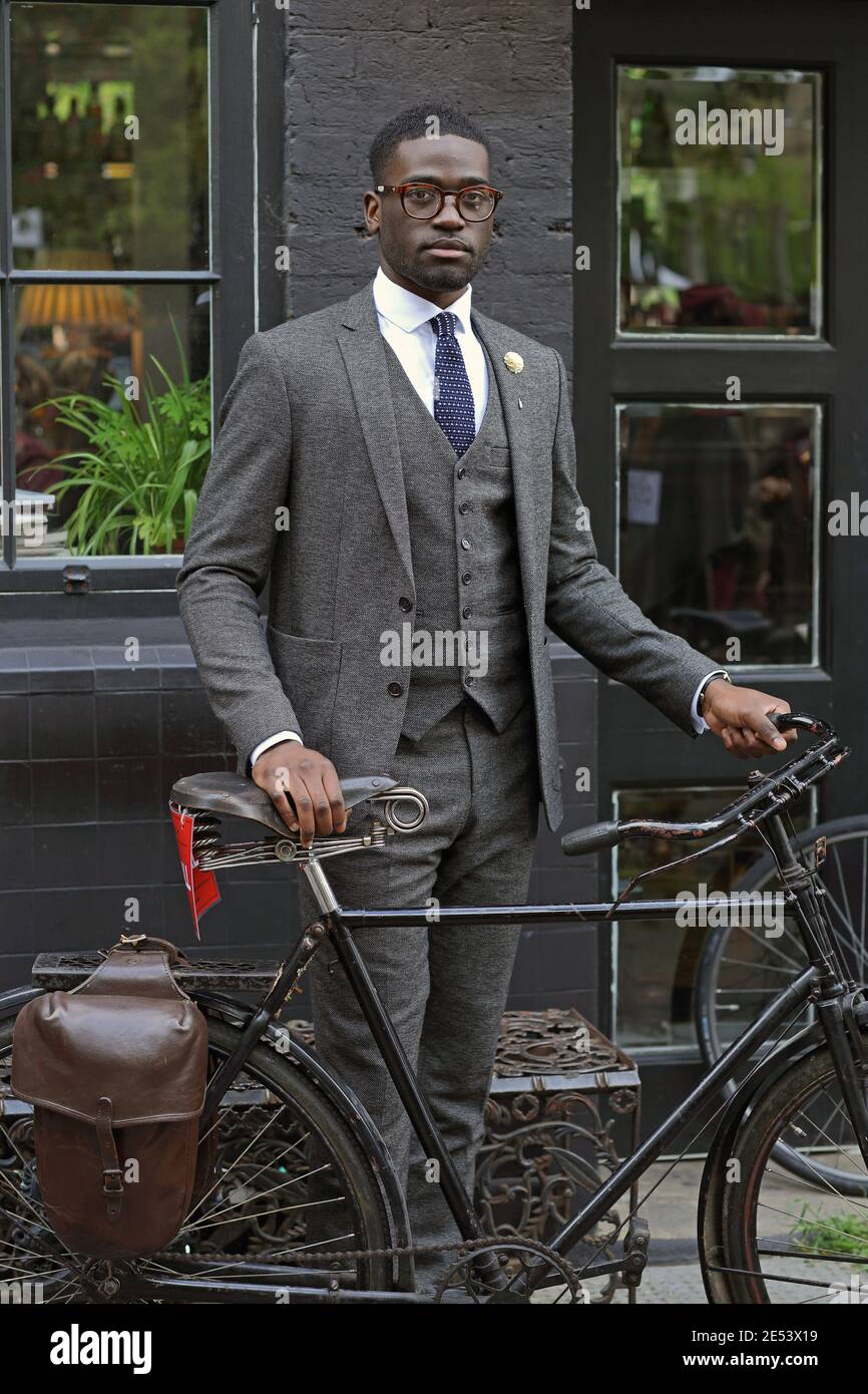 young businessman wearing a suit riding a bike Stock Photo