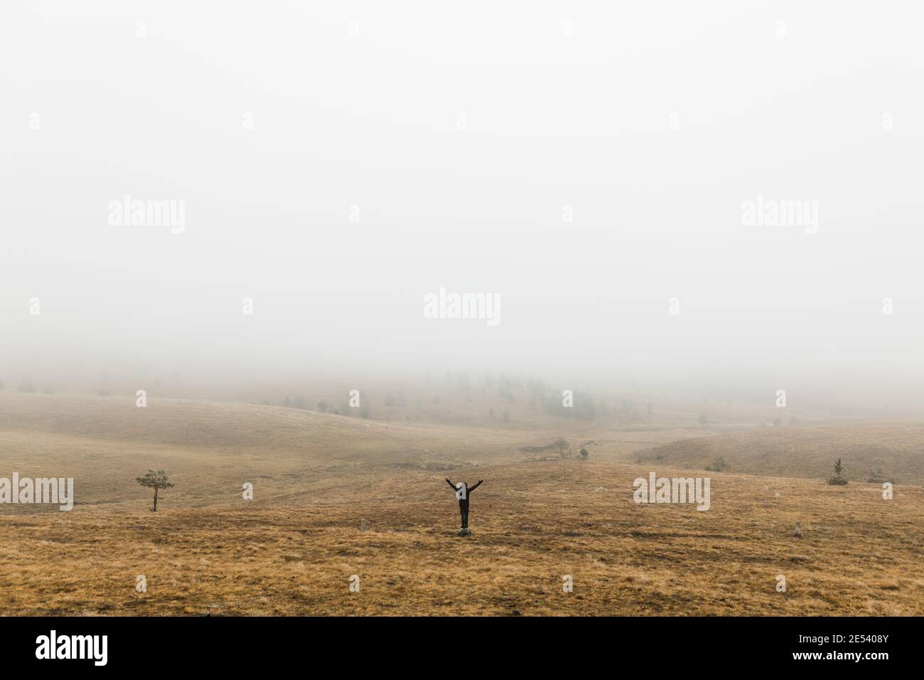 Young man exploring nature on a wet winter morning in the mountains Stock Photo