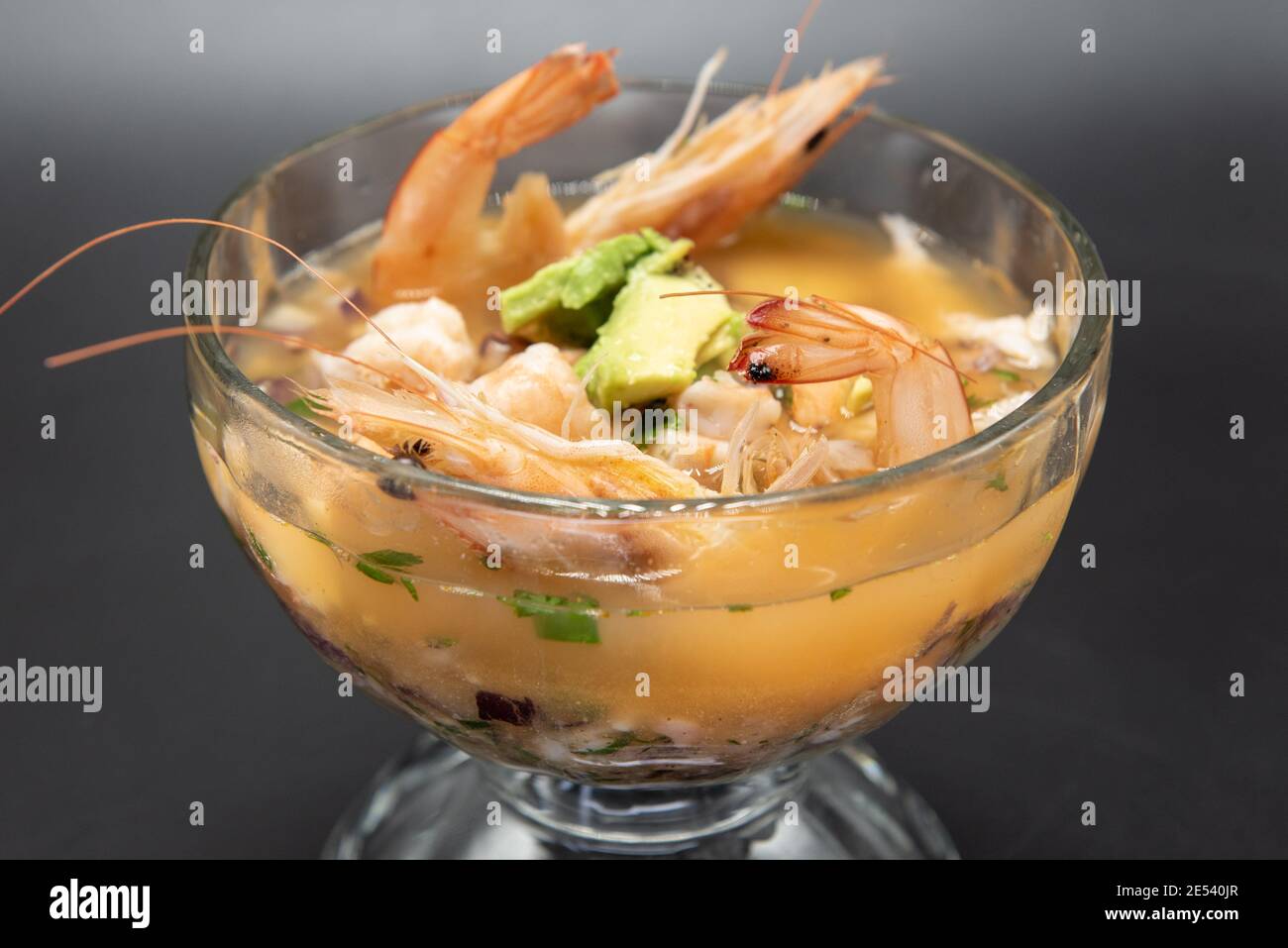 Goblet of warm shrimp broth with head and tail included in soup. Stock Photo
